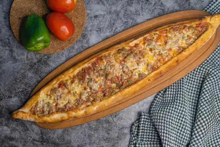 صفيحة لحم خروف وجبنة على لوح خشب بيضاوي